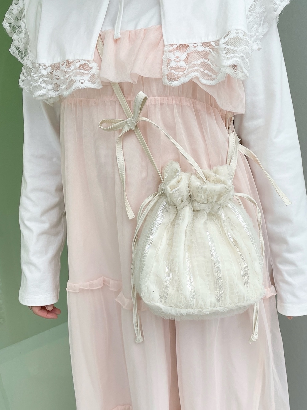 ホワイト系のTシャツ/カットソー、ホワイト系のショルダーバッグ、ピンク系のワンピースを着用したレディースの冬コーディネートの6枚目の写真