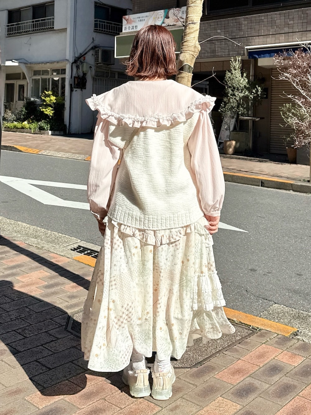 ピンク系のシャツ/ブラウス、ホワイト系のスカート、ホワイト系のショルダーバッグを着用したレディースの冬コーディネートの2枚目の写真