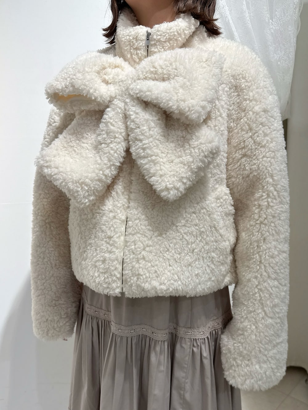 ホワイト系のブルゾン、ピンク系のスカート、ブラウン系のハンドバッグを着用したレディースの秋コーディネートの7枚目の写真
