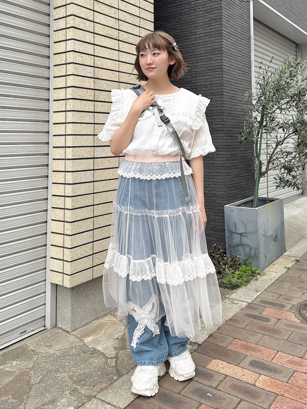 グレー系のショルダーバッグ、ホワイト系のシャツ/ブラウス、ピンク系のスカートを着用したレディースの春コーディネートの2枚目の写真