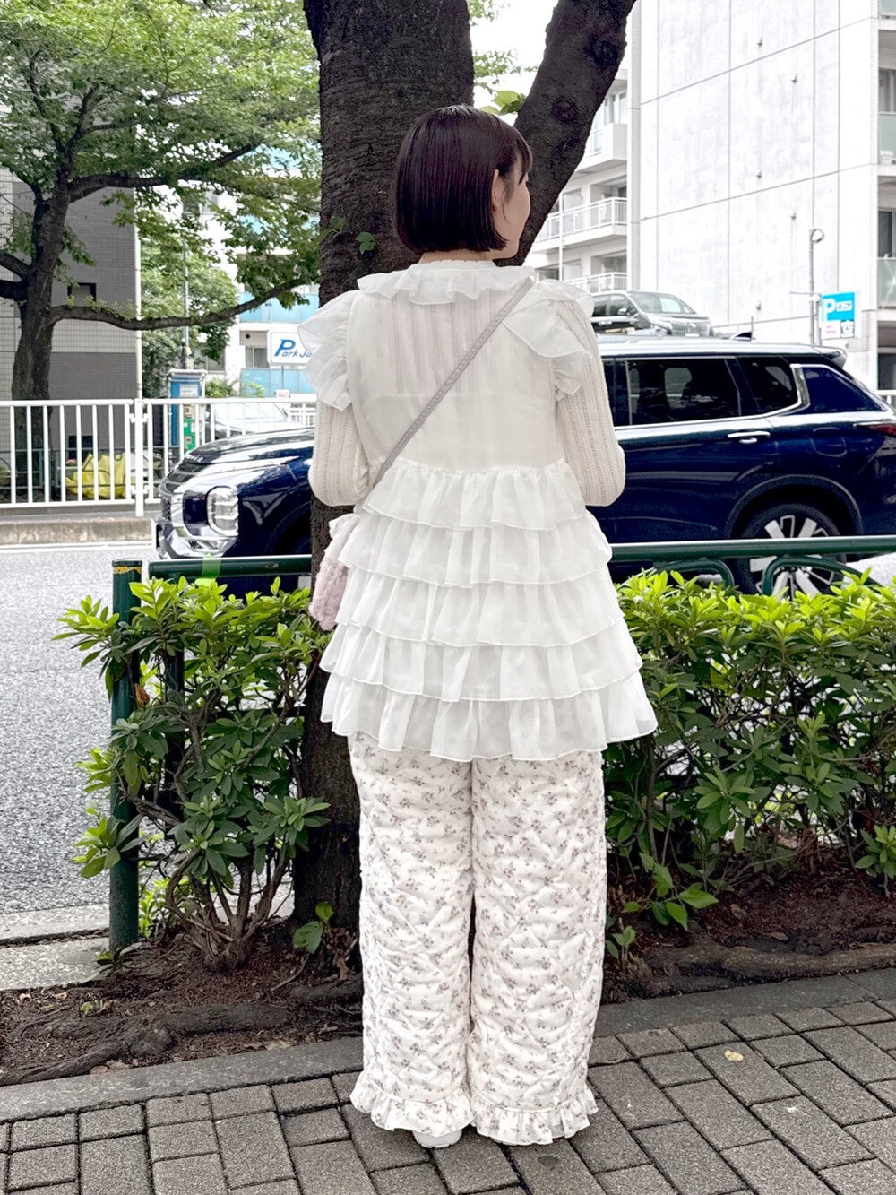 ホワイト系のシャツ/ブラウス、ホワイト系のニット/セーター、ピンク系のハンドバッグを着用したレディースの夏コーディネートの3枚目の写真