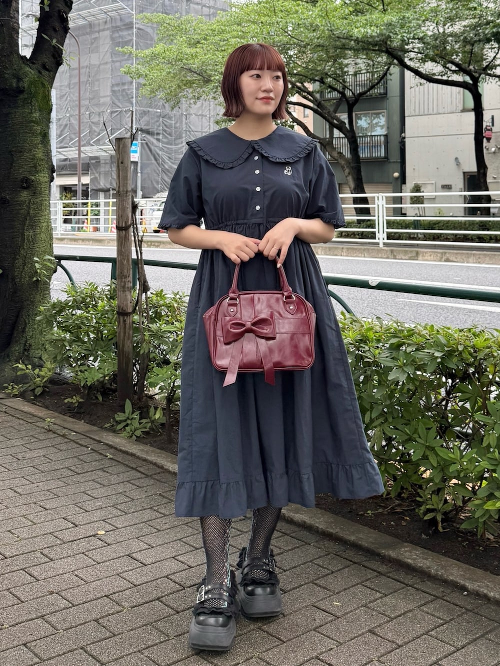 ブルー系のワンピース、レッド系のハンドバッグ、ブラック系のスニーカーを着用したレディースの夏コーディネートの2枚目の写真