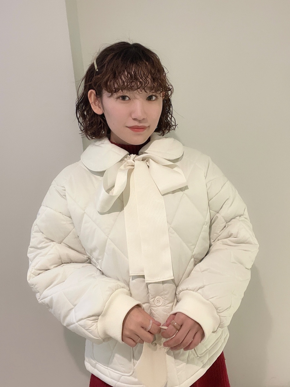 ホワイト系のその他アウター、レッド系のワンピース、ベージュ系のブーツを着用したレディースの冬コーディネートの4枚目の写真