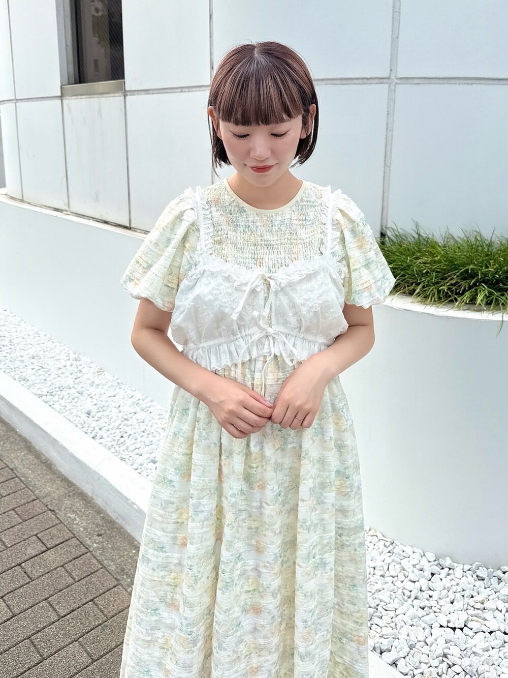 イエロー系のワンピース、ホワイト系のシャツ/ブラウス、ホワイト系のスニーカーを着用したレディースの夏コーディネートの4枚目の写真