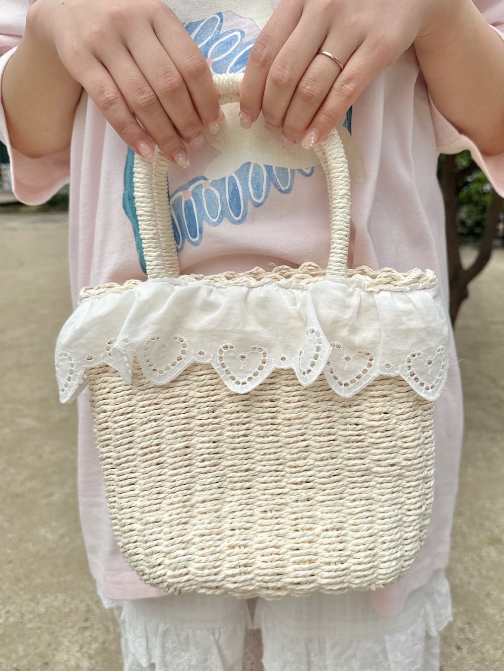 ピンク系のTシャツ/カットソー、ホワイト系のかごバッグ、ホワイト系のスニーカーを着用したレディースの春コーディネートの7枚目の写真