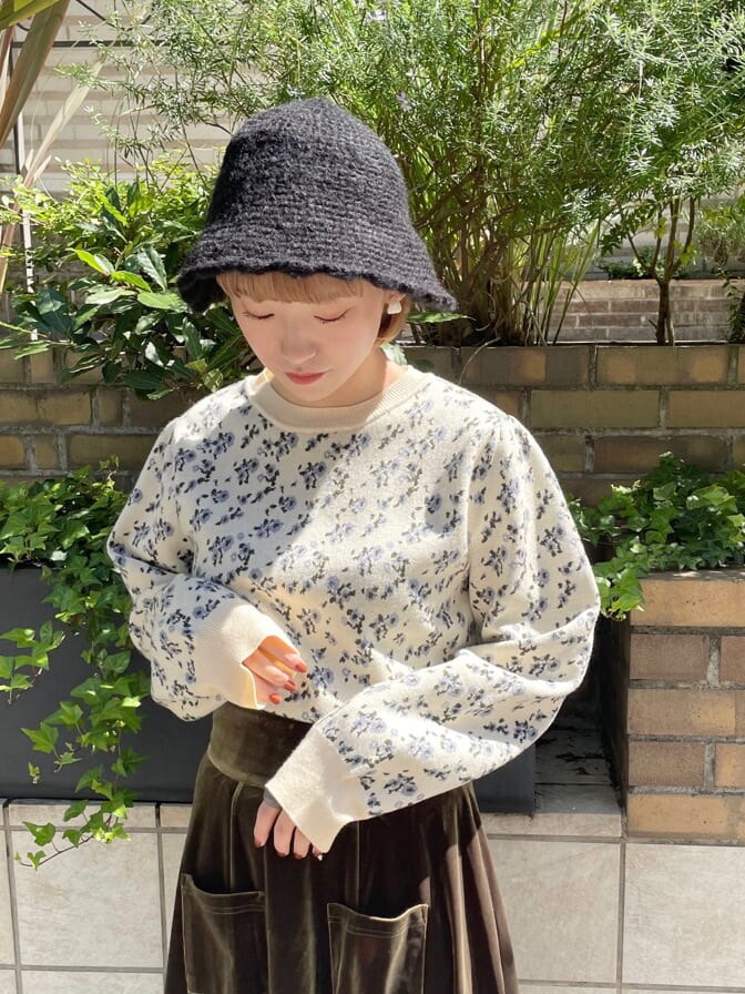 ホワイト系のニット/セーター、ホワイト系のその他シューズ、ベージュ系のスカートを着用したレディースの秋コーディネートの4枚目の写真