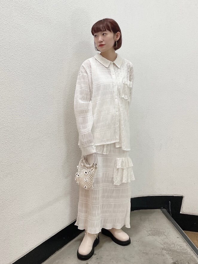 ホワイト系のシャツ/ブラウス、ホワイト系のスカート、ホワイト系のブーツを着用したレディースの夏コーディネートの2枚目の写真