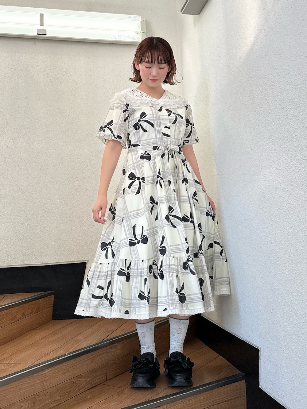 ホワイト系のワンピース、ブラック系のスニーカーを着用したレディースの冬コーディネートの2枚目の写真