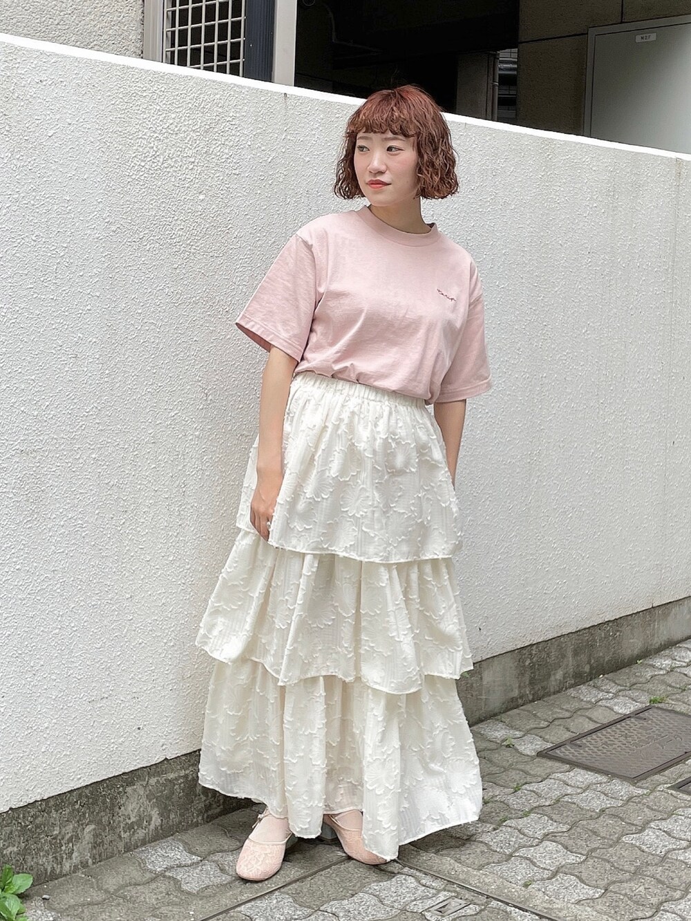 ピンク系のTシャツ/カットソー、ホワイト系のスカート、ピンク系のパンプスを着用したレディースの春コーディネートの2枚目の写真