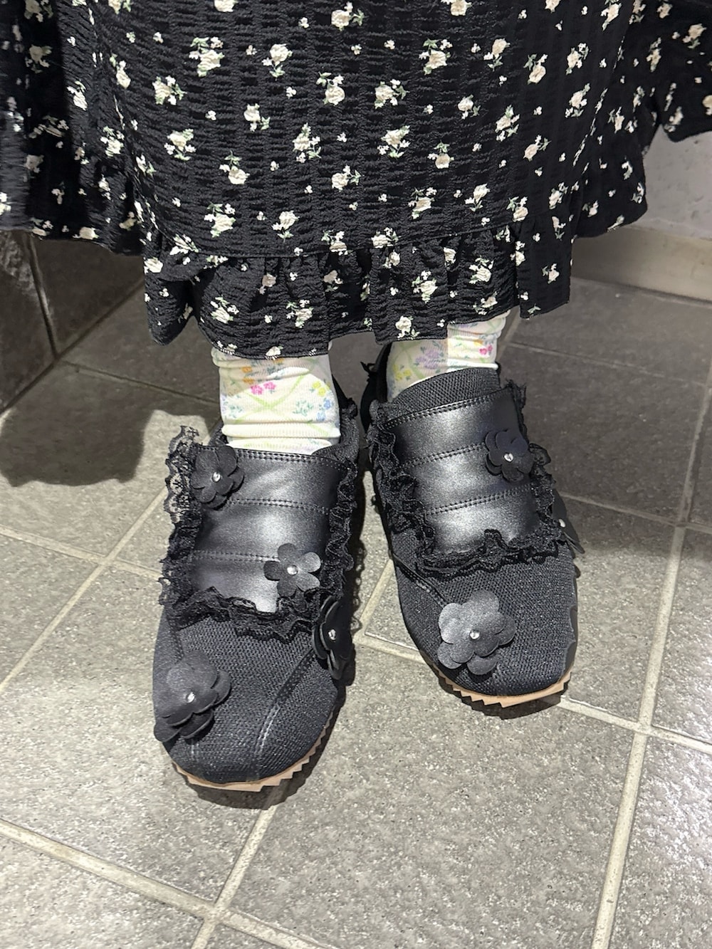 ブラック系のワンピース、ブラック系のスニーカー、ピンク系のネックレスを着用したレディースの春コーディネートの7枚目の写真