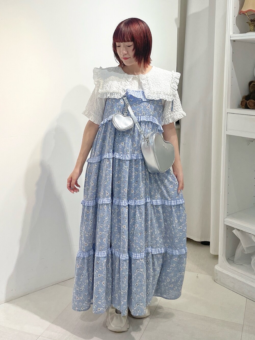 シルバー系のショルダーバッグ、ブルー系のワンピース、ホワイト系のシャツ/ブラウスを着用したレディースの夏コーディネートの2枚目の写真