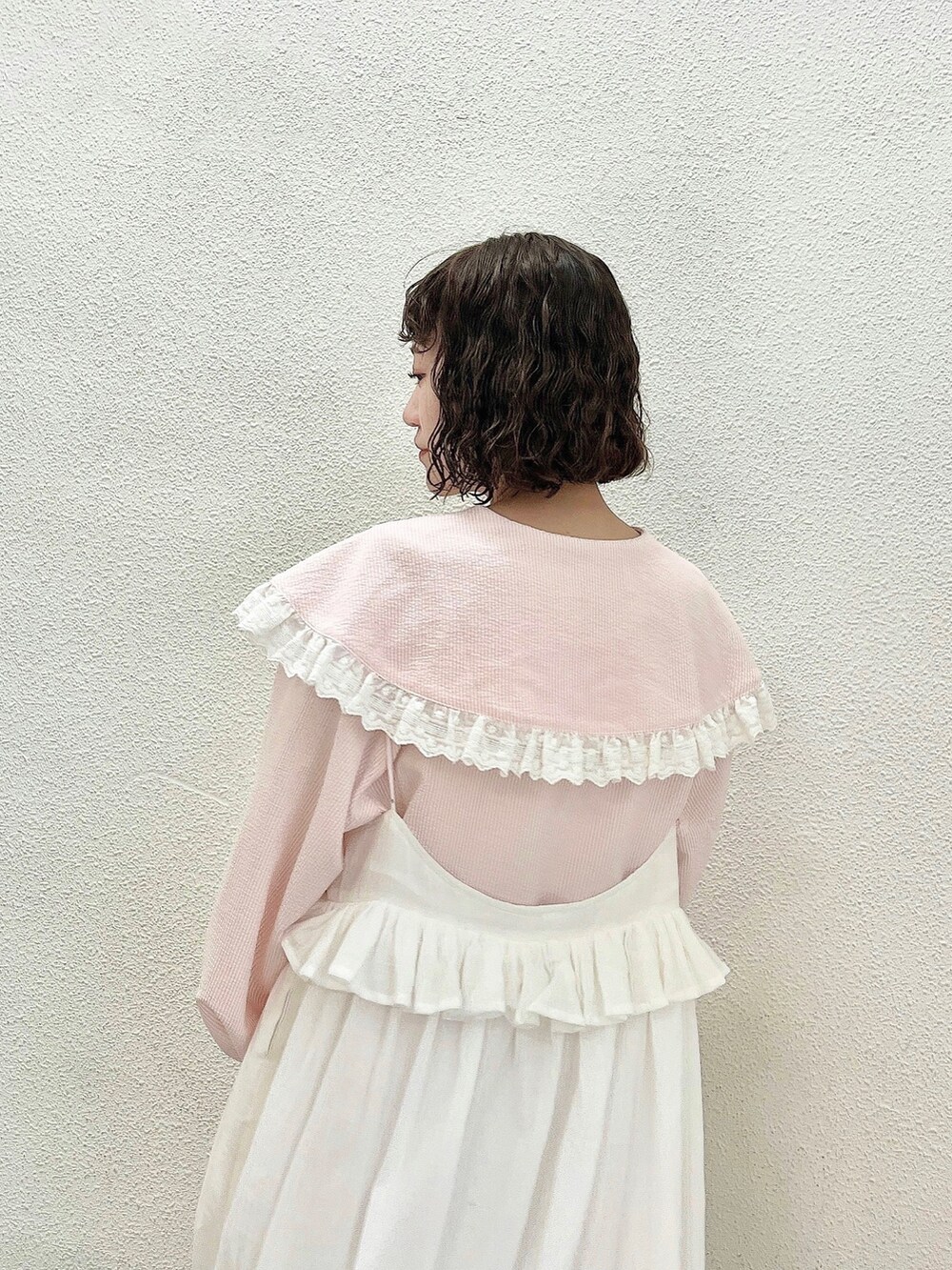 ピンク系のシャツ/ブラウス、ホワイト系のスカート、ピンク系のパンプスを着用したレディースの春コーディネートの5枚目の写真