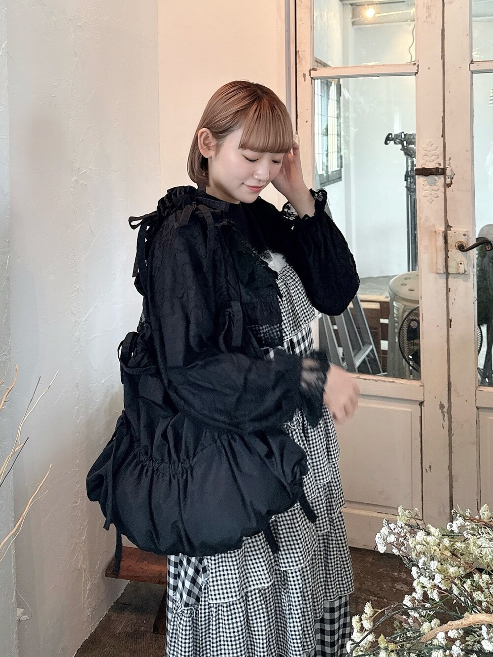 ブラック系のニット/セーター、ブラック系のカーディガン/ボレロ、ブラック系のトートバッグを着用したレディースの春コーディネートの3枚目の写真