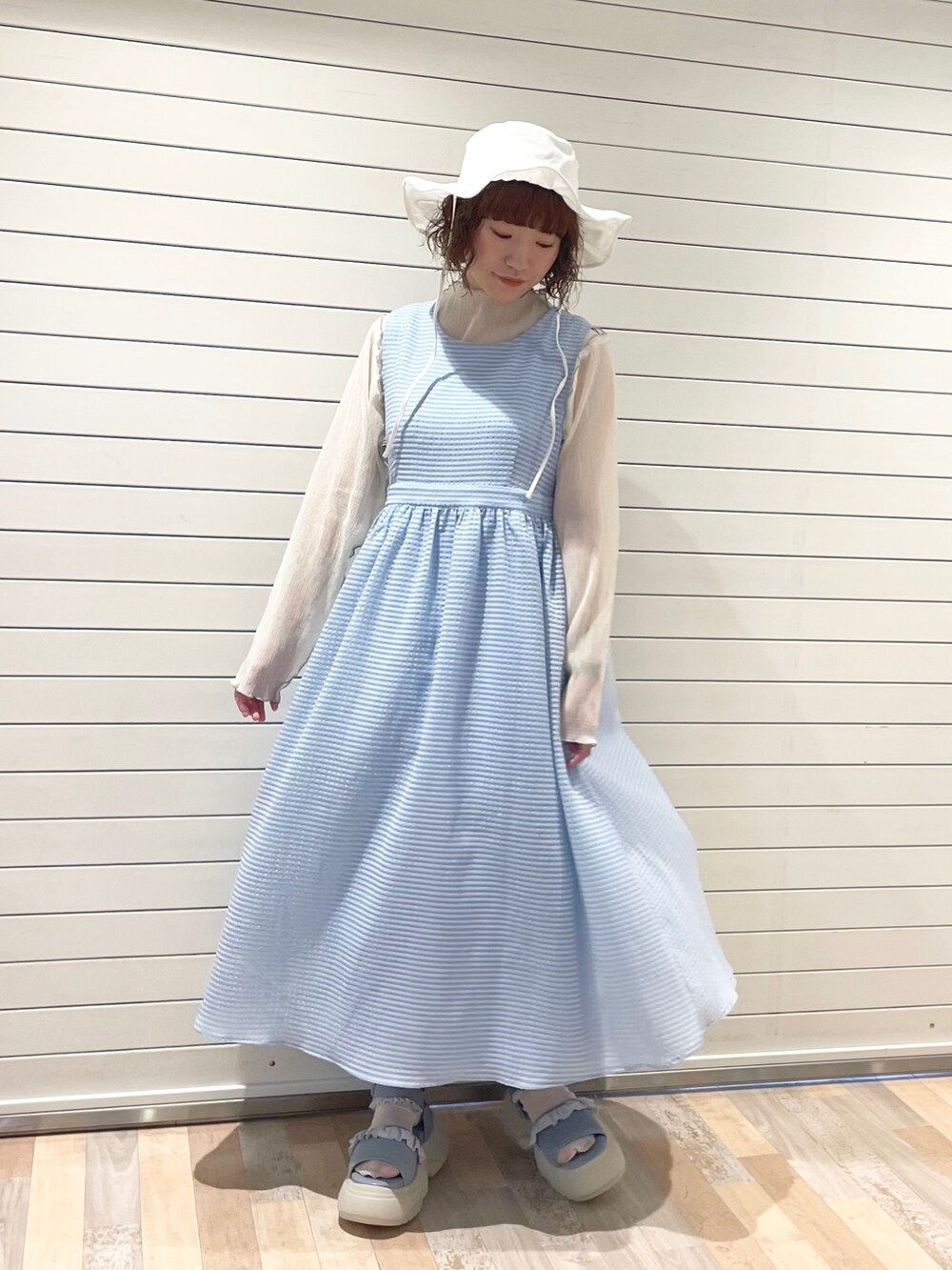 ブルー系のワンピース、ホワイト系のTシャツ/カットソー、ブルー系のサンダルを着用したレディースの夏コーディネートの2枚目の写真