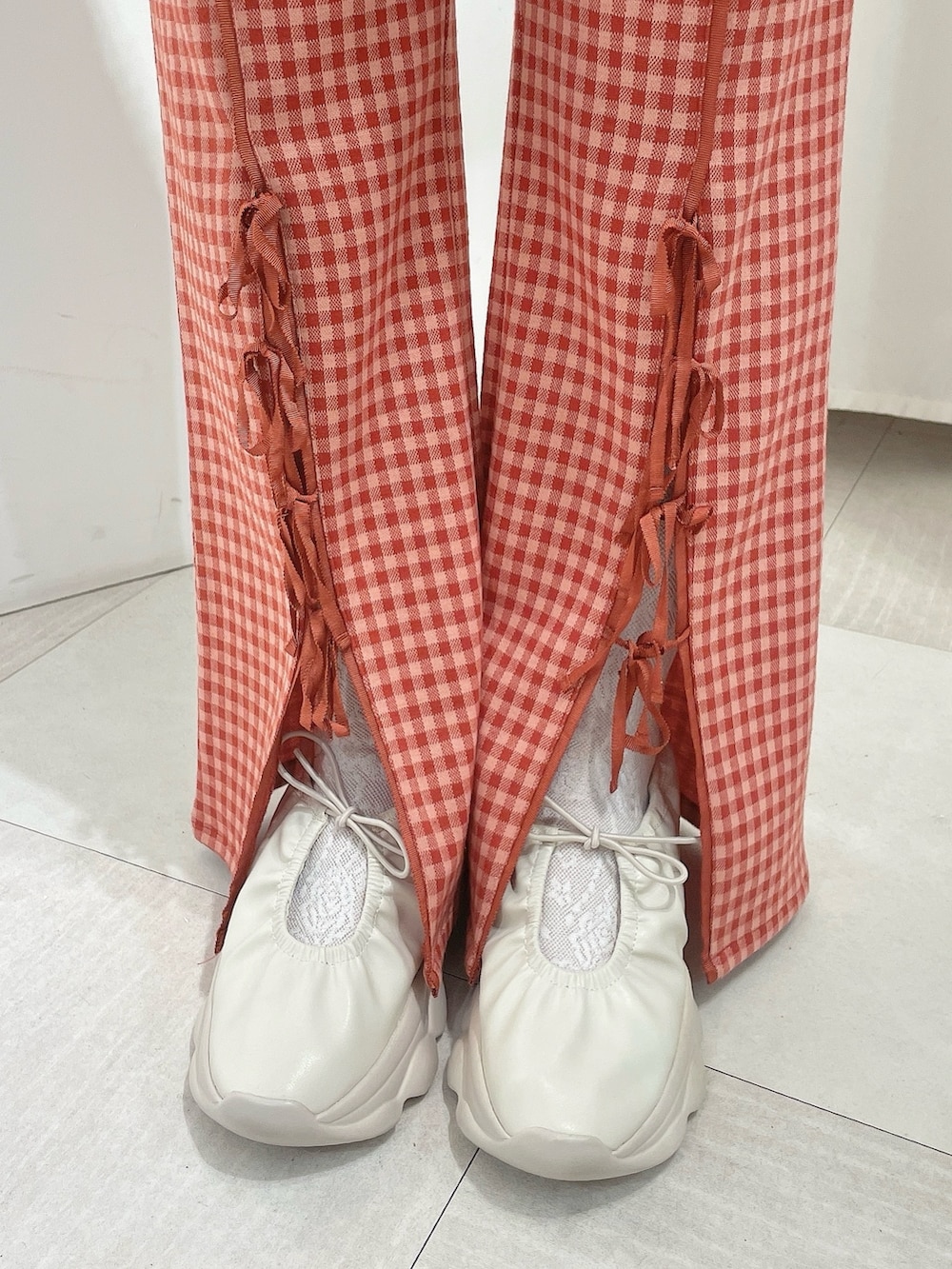 ホワイト系のシャツ/ブラウス、ピンク系のスウェット、レッド系のスラックスを着用したレディースの春コーディネートの6枚目の写真