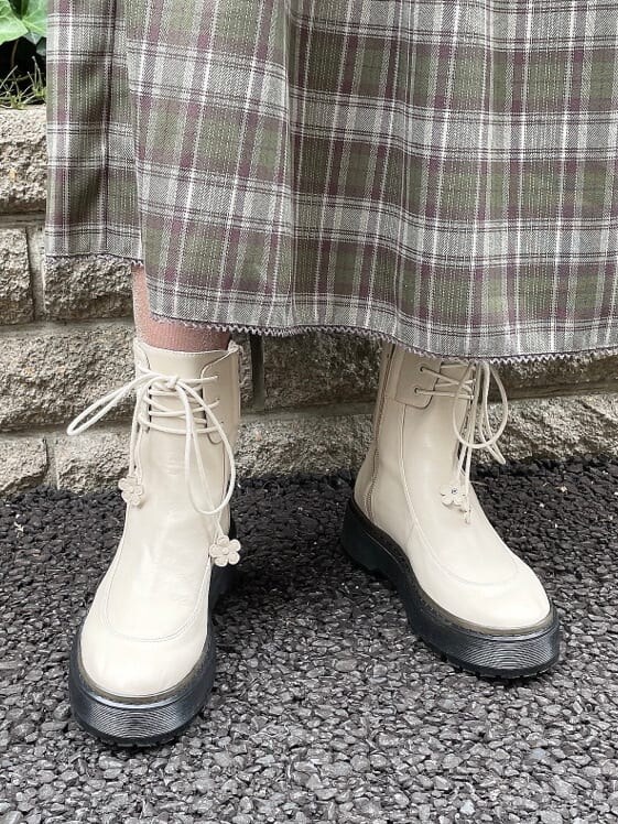 ホワイト系のブーツ、ゴールド系のカーディガン/ボレロ、グリーン系のワンピースを着用したレディースの秋コーディネートの6枚目の写真