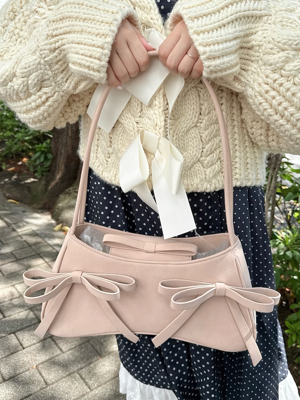 ホワイト系のカーディガン/ボレロ、ピンク系のハンドバッグ、ブラック系のローファーを着用したレディースの秋コーディネートの6枚目の写真