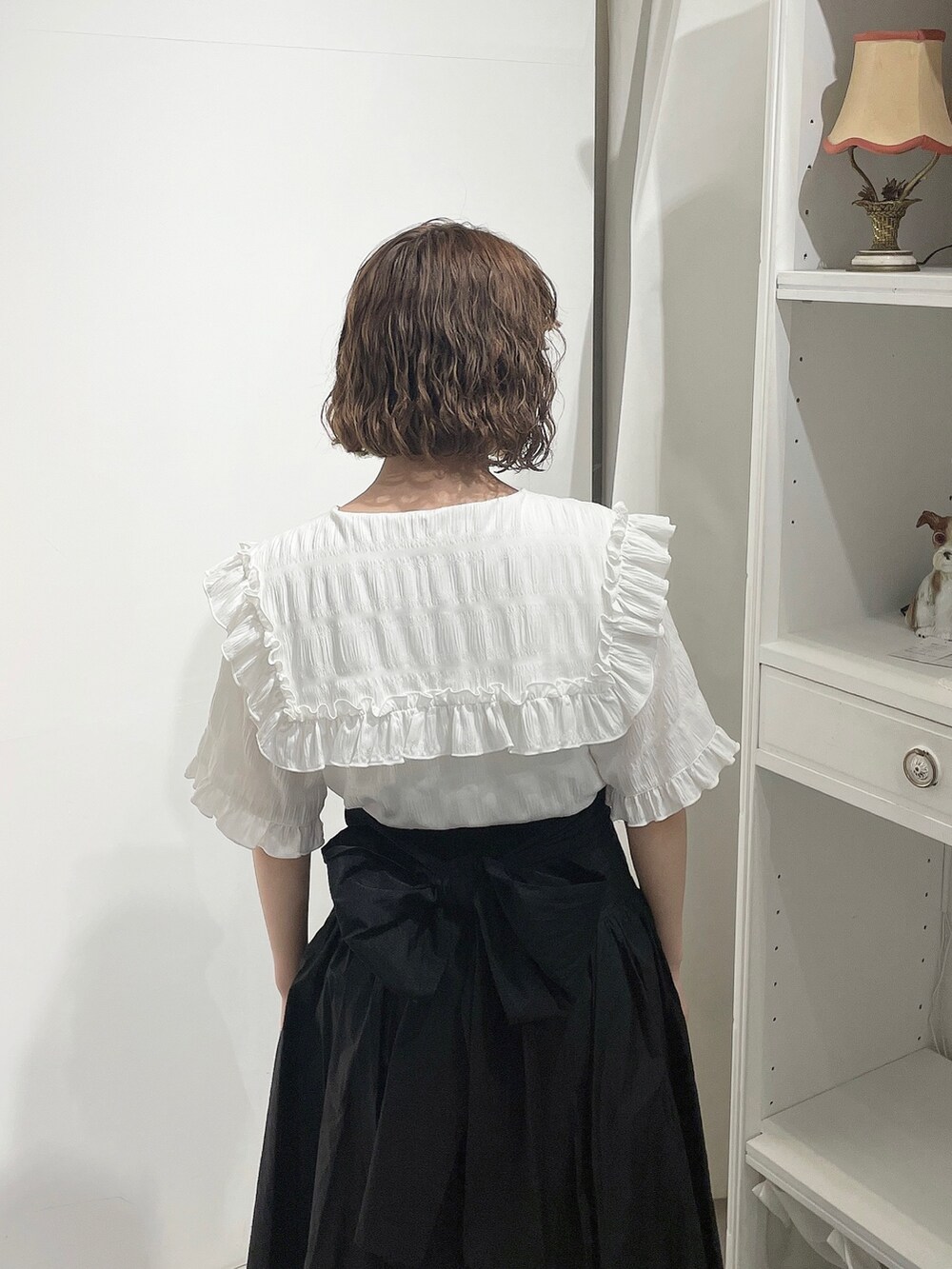 ホワイト系のシャツ/ブラウス、ブラック系のスカート、ホワイト系のパンプスを着用したレディースの春コーディネートの5枚目の写真