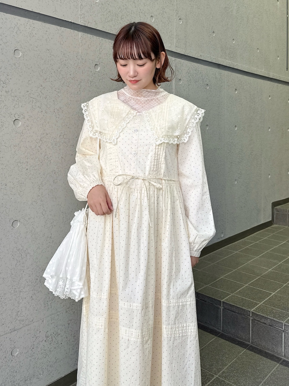 ベージュ系のワンピース、ピンク系のTシャツ/カットソー、ホワイト系のショルダーバッグを着用したレディースの春コーディネートの4枚目の写真