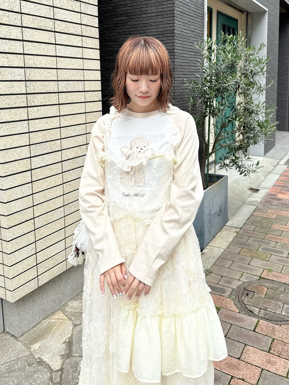 ベージュ系のTシャツ/カットソー、ホワイト系のワンピース、ホワイト系のスカートを着用したレディースの夏コーディネートの5枚目の写真