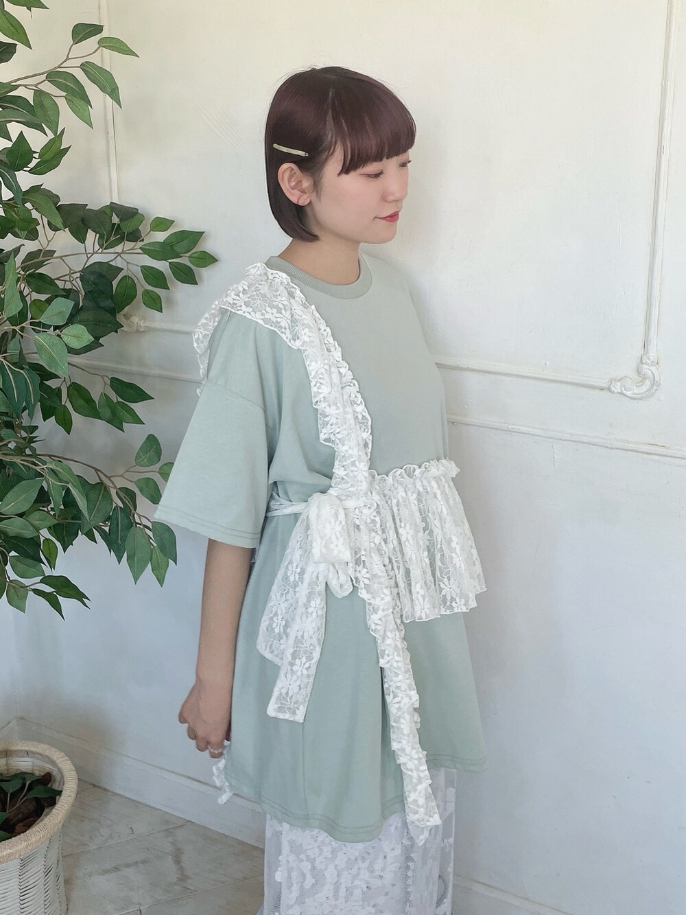 グリーン系のTシャツ/カットソー、ブルー系のデニムパンツ、ホワイト系のスカートを着用したレディースの春コーディネートの6枚目の写真