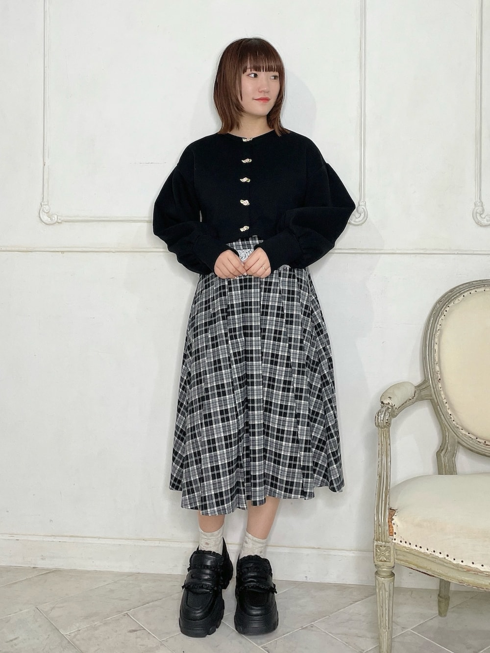 ブラック系のカーディガン/ボレロ、ブラック系のスカート、ブラック系のローファーを着用したレディースの秋コーディネートの2枚目の写真