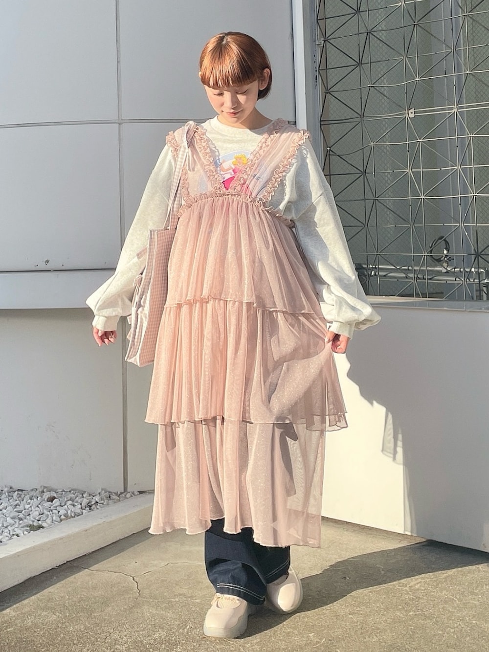 ベージュ系のトートバッグ、グレー系のスウェット、ピンク系のワンピースを着用したレディースの春コーディネートの2枚目の写真