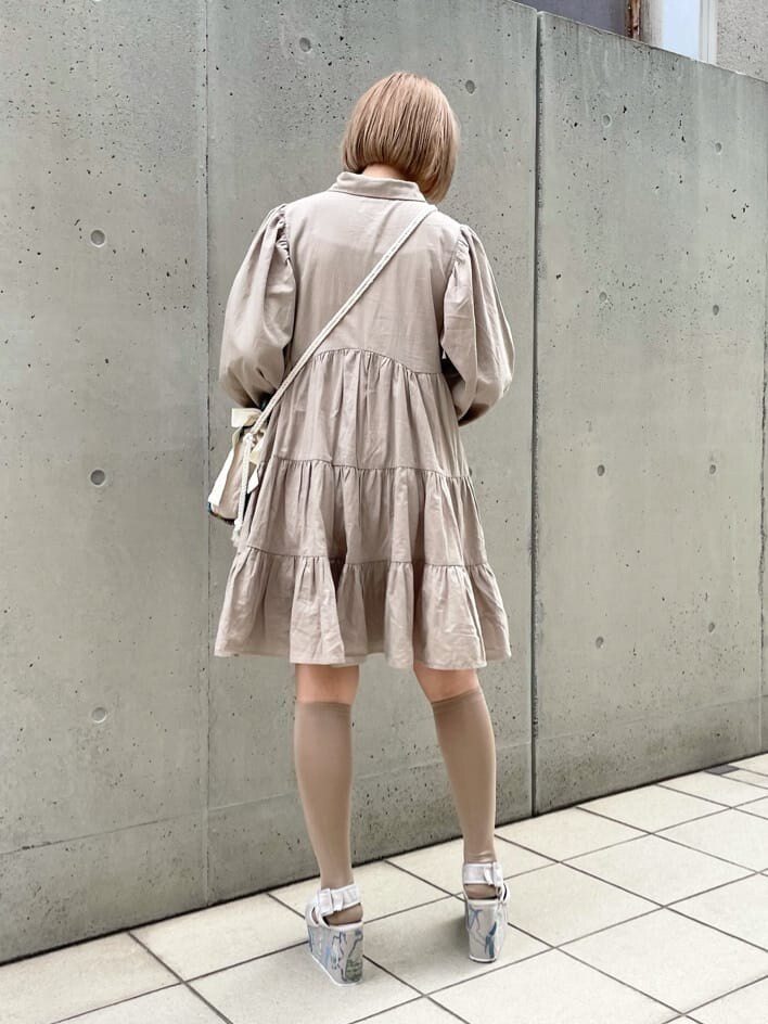 ブラウン系のハンドバッグ、ベージュ系のワンピース、グレー系のサンダルを着用したレディースの夏コーディネートの4枚目の写真