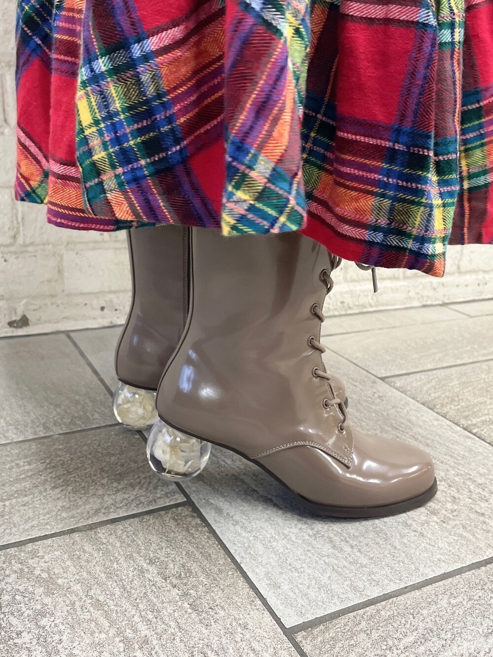 ホワイト系のニット/セーター、レッド系のスカート、ベージュ系のブーツを着用したレディースの冬コーディネートの6枚目の写真