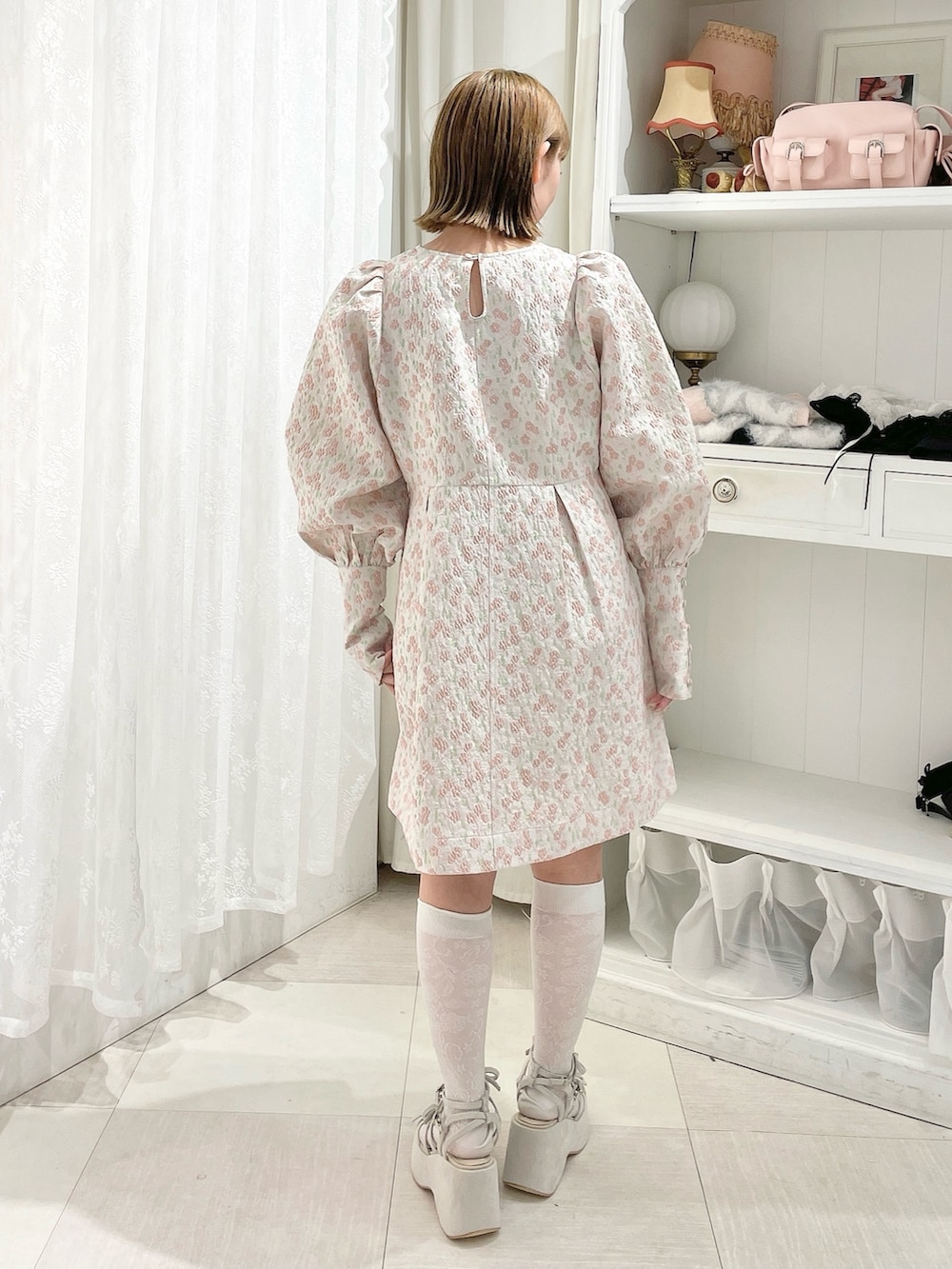 ピンク系のワンピース、ベージュ系のサンダルを着用したレディースの冬コーディネートの3枚目の写真