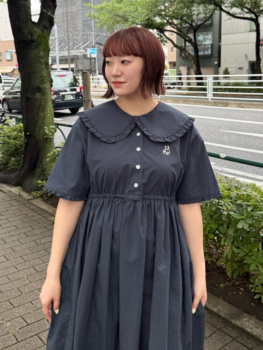 ブルー系のワンピース、レッド系のハンドバッグ、ブラック系のスニーカーを着用したレディースの夏コーディネートの3枚目の写真