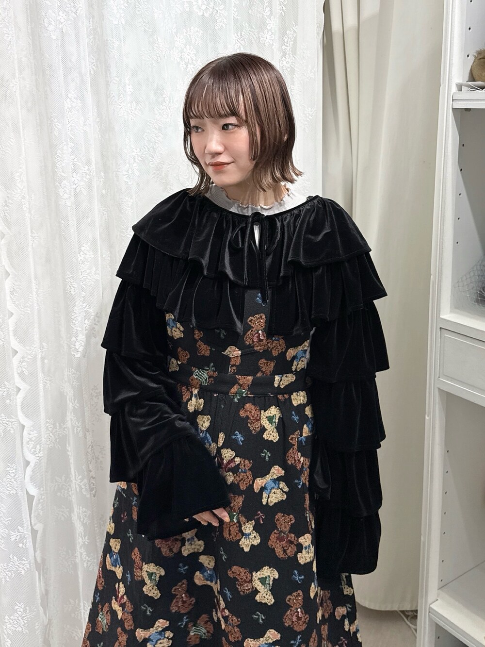 グレー系のニット/セーター、ブラック系のカーディガン/ボレロ、ブラック系のジャンパースカートを着用したレディースの秋コーディネートの5枚目の写真