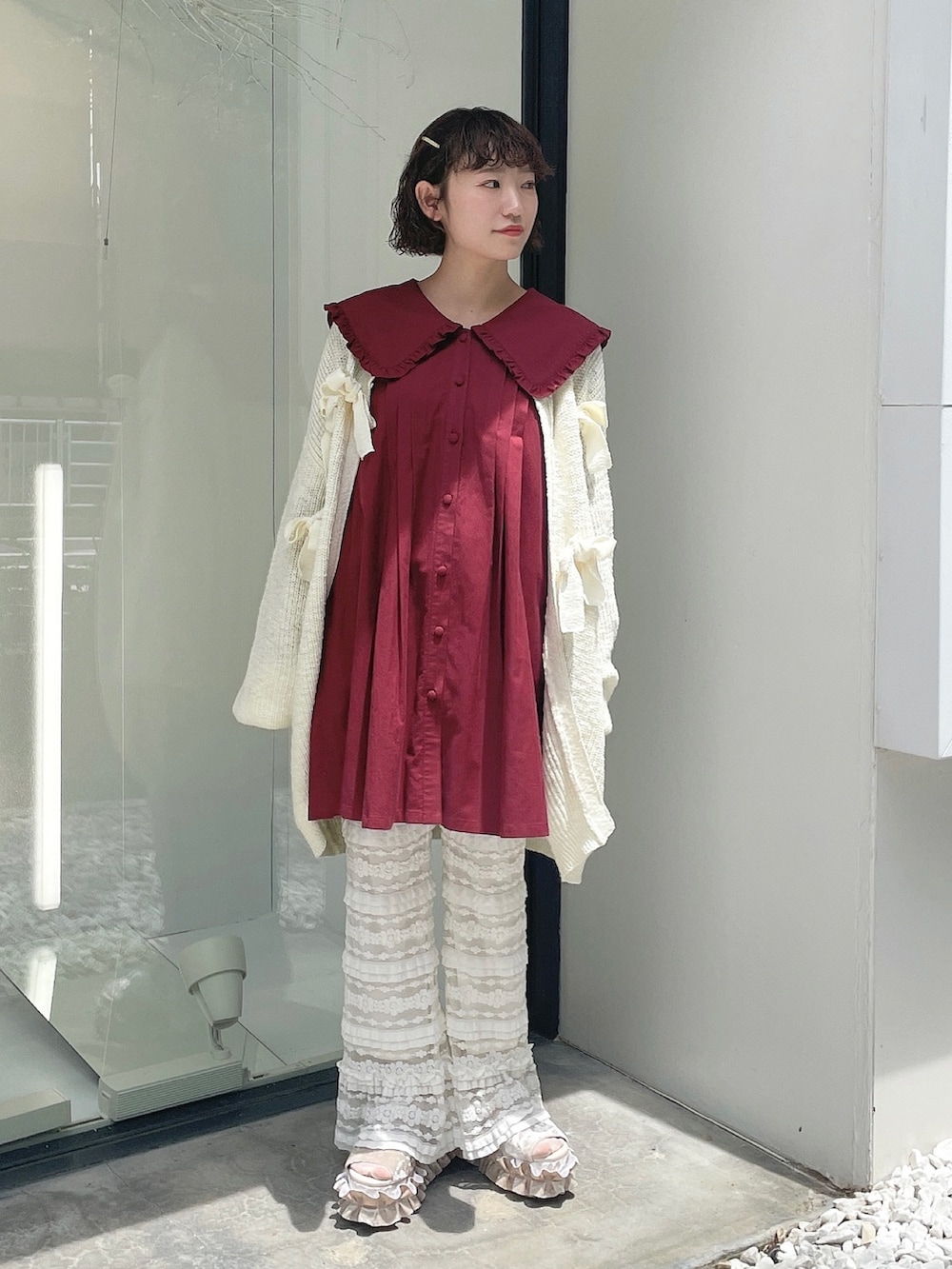 レッド系のワンピース、ホワイト系のカーディガン/ボレロ、ホワイト系のスウェットパンツを着用したレディースの夏コーディネートの2枚目の写真