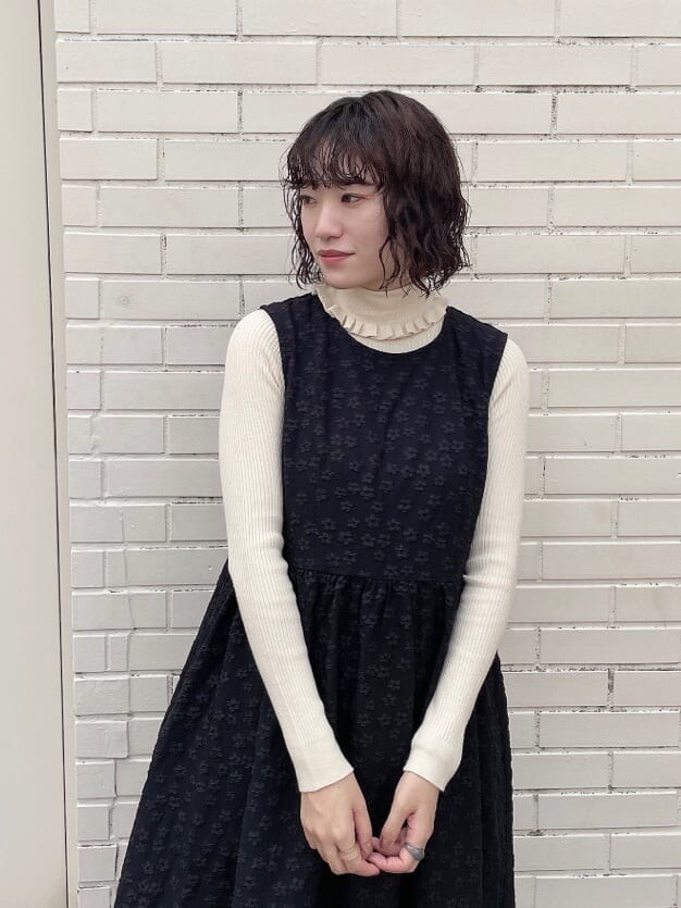 ブラック系のワンピース、ブラック系のパンプス、ホワイト系のニット/セーターを着用したレディースの秋コーディネートの6枚目の写真