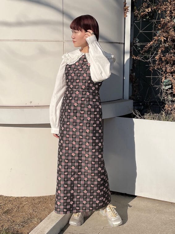 ピンク系のワンピース、ホワイト系のシャツ/ブラウス、ホワイト系のスニーカーを着用したレディースの冬コーディネートの2枚目の写真