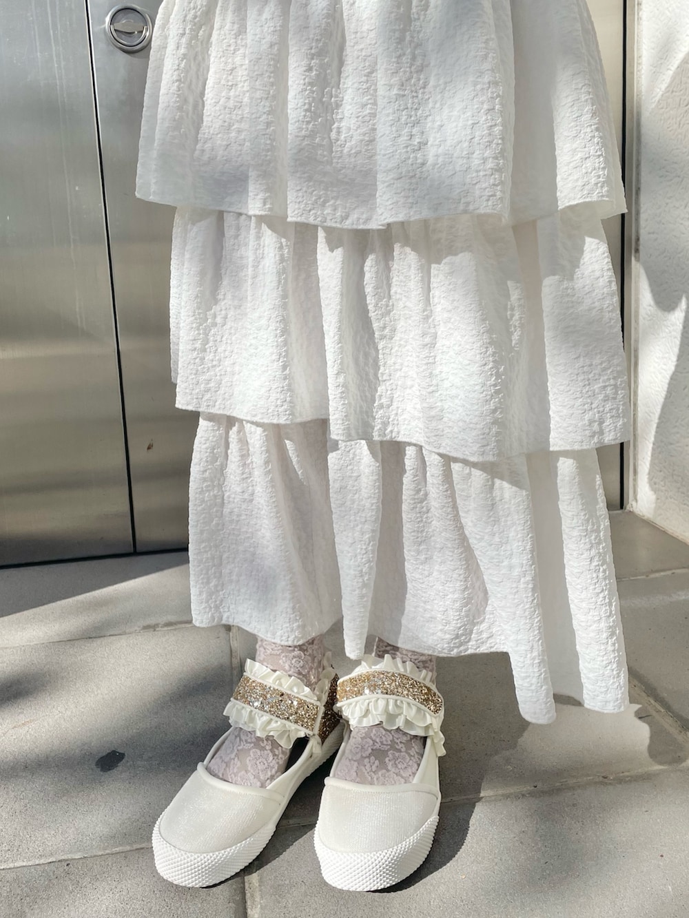 ホワイト系のスカート、ベージュ系のブルゾン、ホワイト系のニット/セーターを着用したレディースの冬コーディネートの8枚目の写真