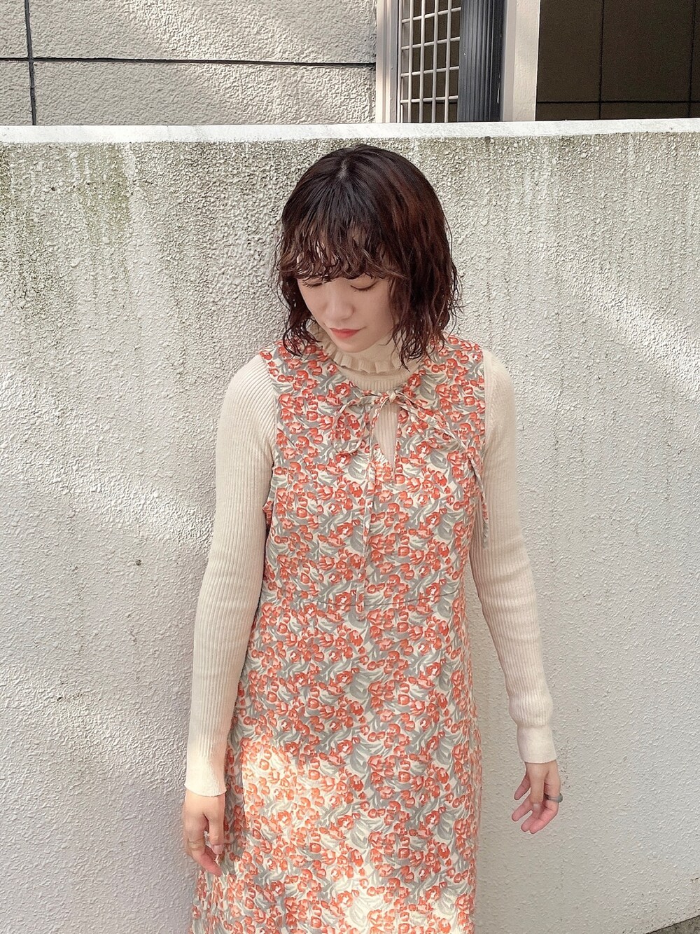 ブラウン系のその他アウター、ホワイト系のニット/セーター、オレンジ系のワンピースを着用したレディースの秋コーディネートの6枚目の写真