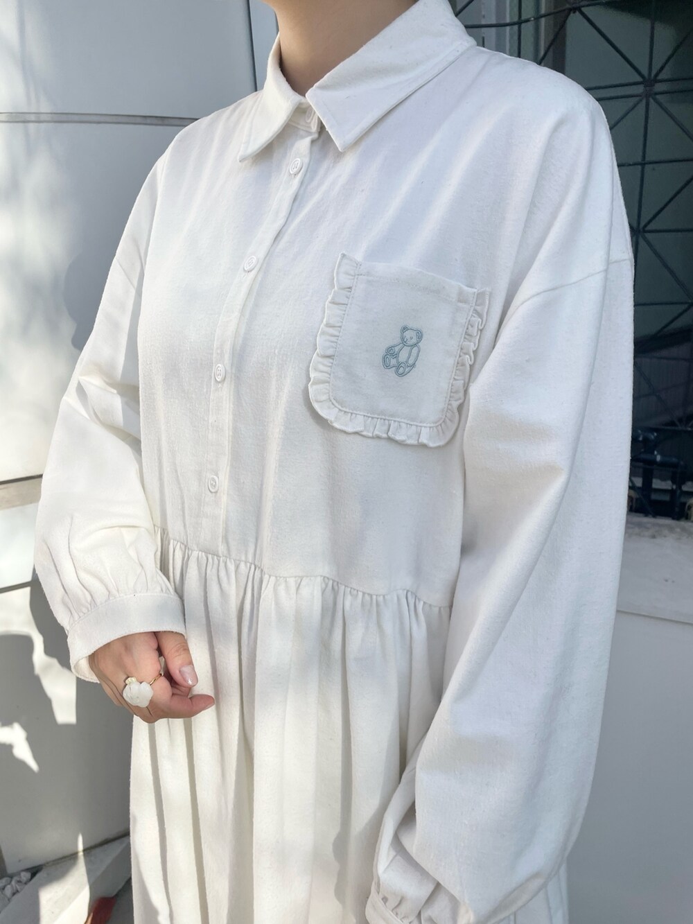 ホワイト系のダウンジャケット/コート、ホワイト系のワンピース、ホワイト系のスニーカーを着用したレディースの冬コーディネートの9枚目の写真