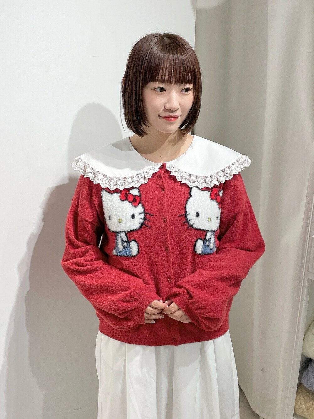 ホワイト系のワンピース、レッド系のカーディガン/ボレロ、ホワイト系のローファーを着用したレディースの秋コーディネートの5枚目の写真