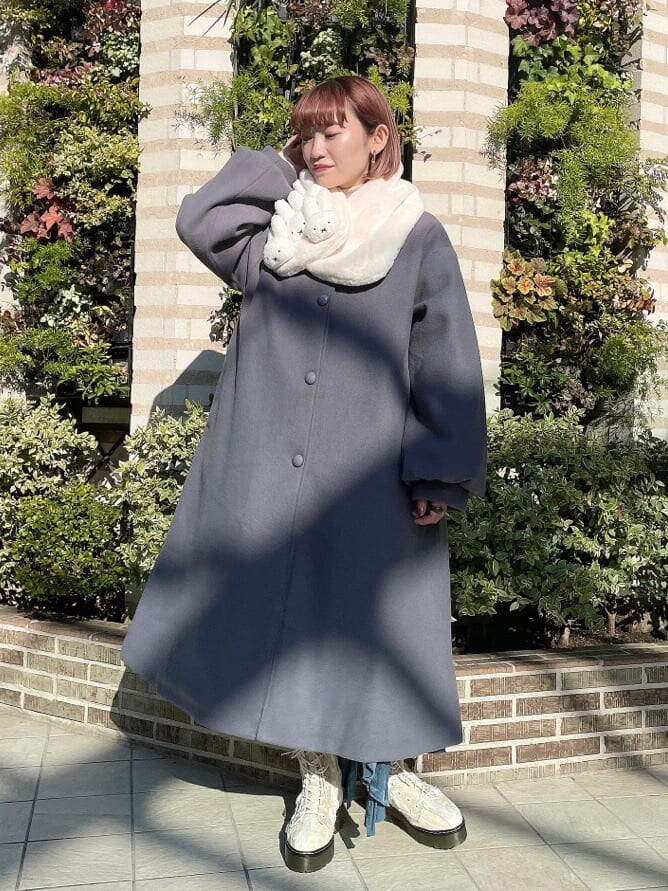 ホワイト系のニット/セーター、ブルー系のステンカラーコート、ブルー系のスカートを着用したレディースの冬コーディネートの2枚目の写真
