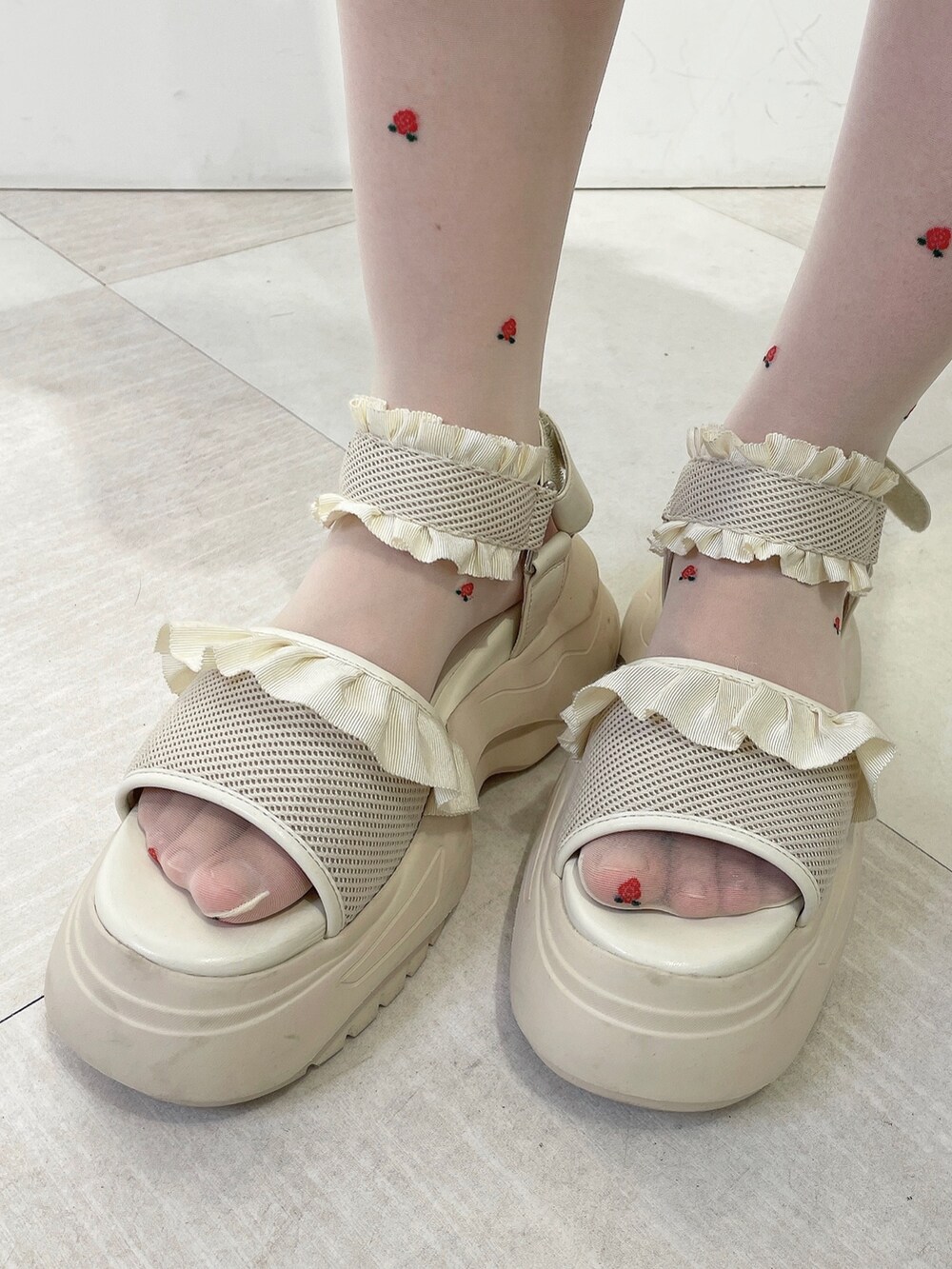 ホワイト系のワンピース、ホワイト系のサンダル、パープル系のキャップを着用したレディースの春コーディネートの7枚目の写真