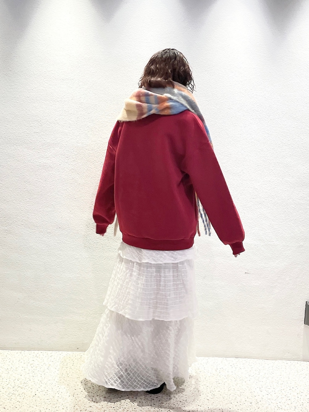 ホワイト系のスカート、ホワイト系のモカシン/デッキシューズ、レッド系のTシャツ/カットソーを着用したレディースの冬コーディネートの3枚目の写真