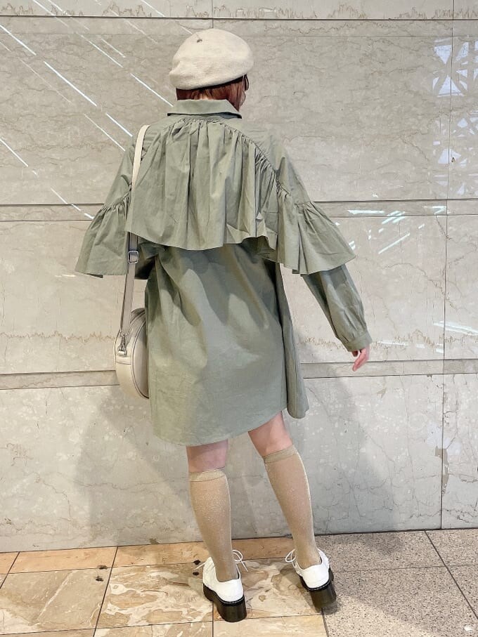 グリーン系のワンピース、ホワイト系のその他シューズ、ホワイト系のショルダーバッグを着用したレディースの冬コーディネートの3枚目の写真