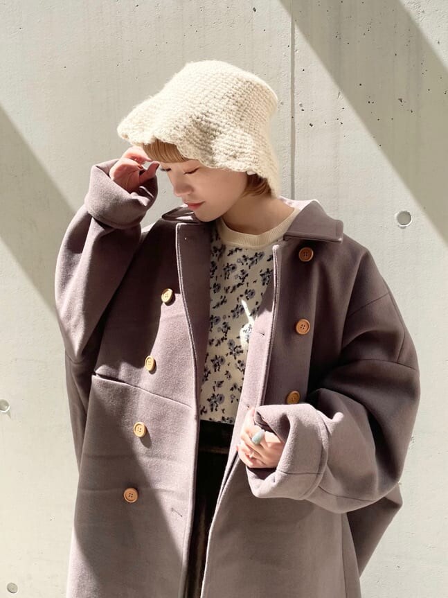 グリーン系のチェスターコート、ホワイト系のその他シューズ、ベージュ系のスカートを着用したレディースの秋コーディネートの3枚目の写真