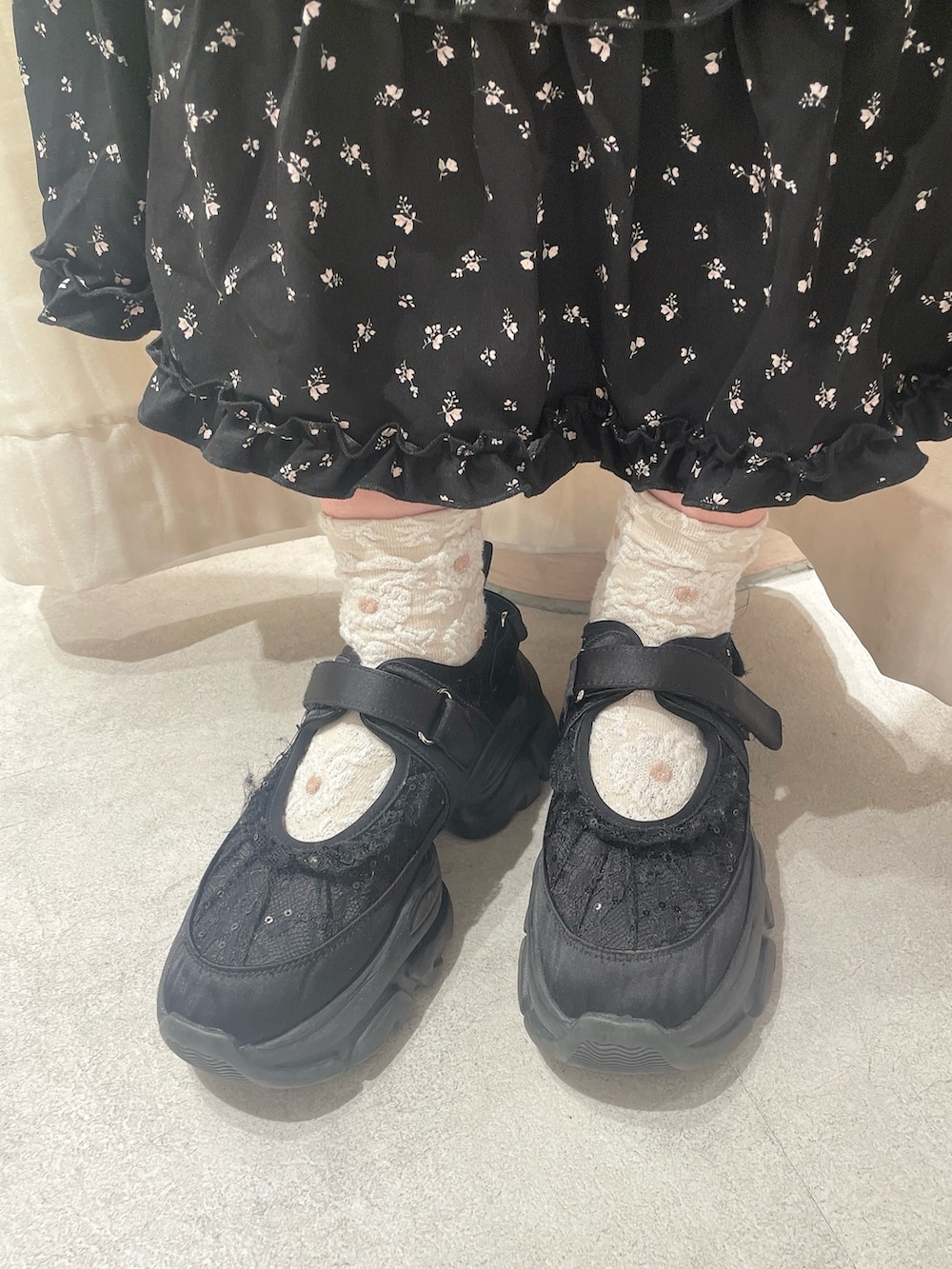 ブラック系のワンピース、グレー系のテーラードジャケット、ブラック系のスニーカーを着用したレディースの冬コーディネートの6枚目の写真