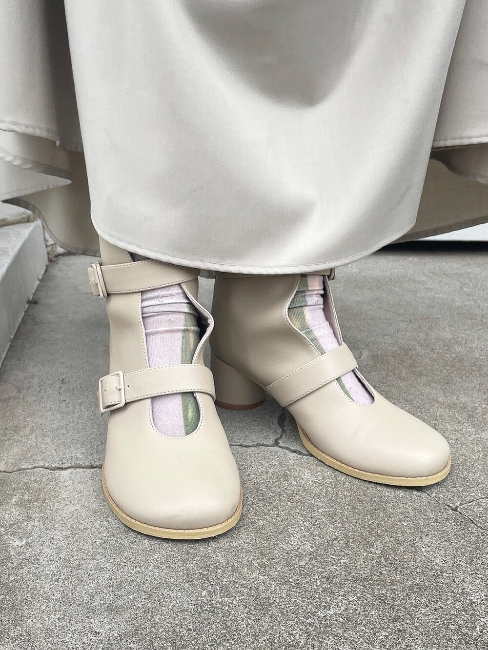 ホワイト系のカーディガン/ボレロ、ホワイト系のTシャツ/カットソー、ベージュ系のスカートを着用したレディースの冬コーディネートの6枚目の写真