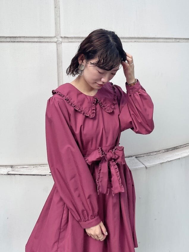 レッド系のワンピース、ブラック系のカーディガン/ボレロ、ブラック系のブーツを着用したレディースの秋コーディネートの6枚目の写真