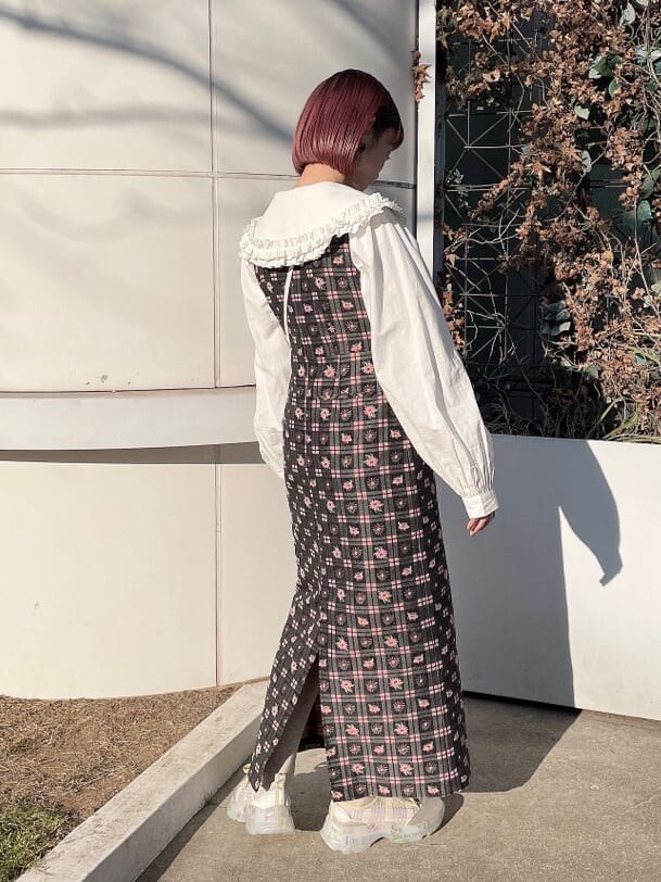 ピンク系のワンピース、ホワイト系のシャツ/ブラウス、ホワイト系のスニーカーを着用したレディースの冬コーディネートの3枚目の写真