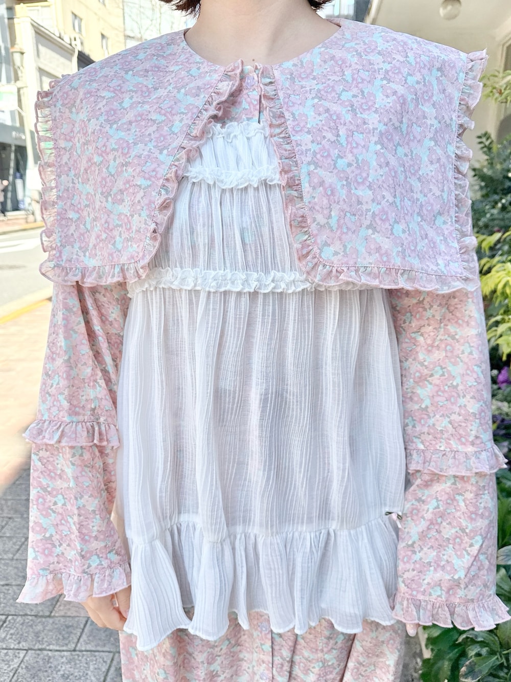 ピンク系のワンピース、ホワイト系のショルダーバッグ、ホワイト系のチュニックを着用したレディースの冬コーディネートの5枚目の写真