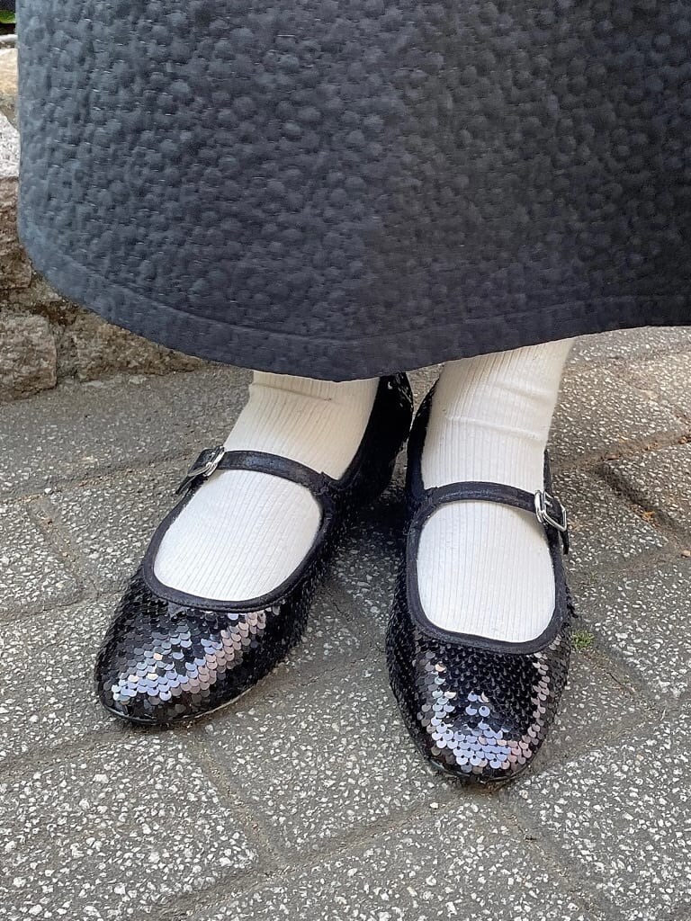 ブラック系のパンプス、ブラック系のその他アウター、ホワイト系のシャツ/ブラウスを着用したレディースの冬コーディネートの5枚目の写真
